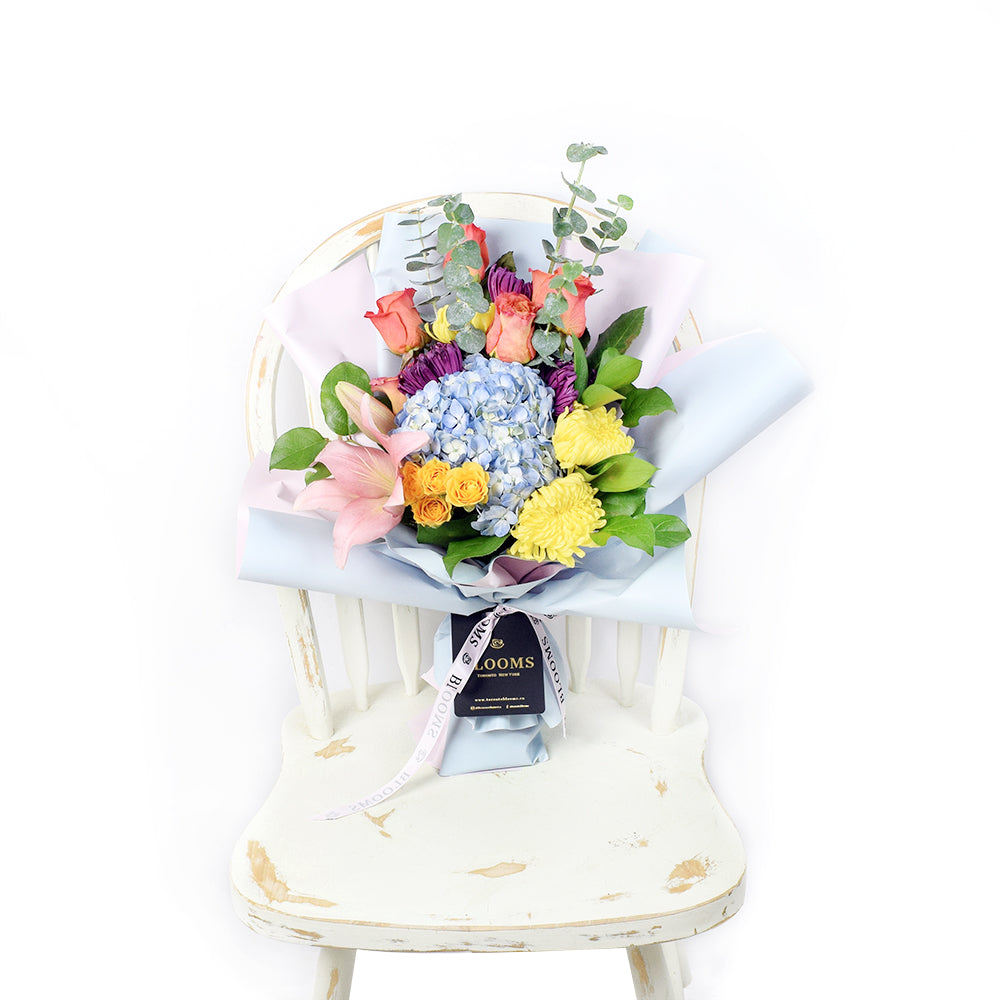 The Festive Purim Bouquet from Connecticut Blooms features a cheerful arrangement of roses, cremons and other flowers tied with a designer ribbon